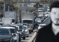 Heavy Traffic on a Multi-lane Highway with Cars and Trucks; a Blurred Man is Visible in the Foreground on the Right. | Ciudadano Seguros
