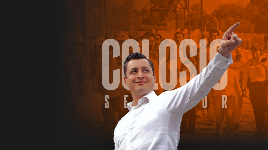 Politician in a White Shirt Points Upward Against an Orange-tinted Crowd and Large Campaign Text Behind Him. | Ciudadano Seguros