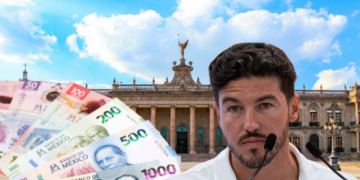 Man Speaking into Two Microphones in Front of a Grand Government-style Building, with a Fanned Pile of Mexican Peso Banknotes in the Foreground | Ciudadano Seguros